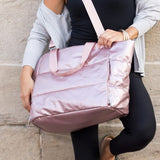 Babe Beachwear large lightweight puffer weekends bag in pink worn crossbody by woman in black outfit