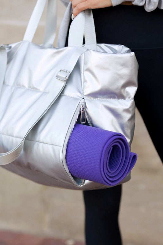 Babe Beachwear large lightweight puffer weekends bag in silver with side zipper holding a purple yoga mat
