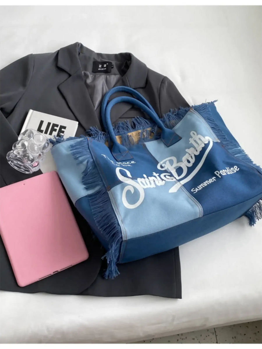 Large resort tote bag with fringe in blue tones featuring Saint Barth logo and summer paradise text