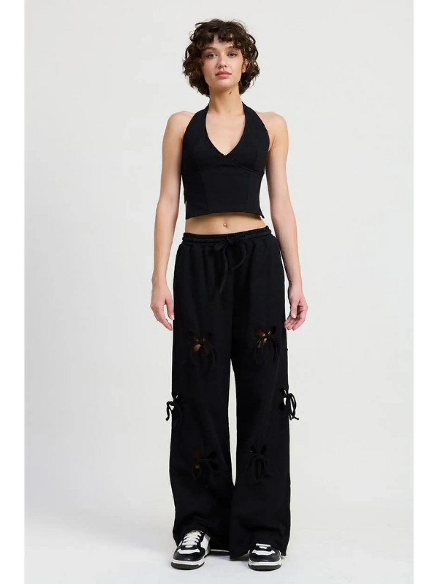 Woman wearing Emory Park black laser cutout cotton beach pants with wide leg and casual fit