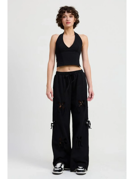 Woman wearing Emory Park black laser cutout cotton beach pants with wide leg and casual fit