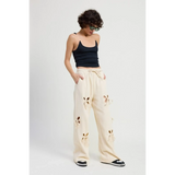Emory Park wide leg laser cutout cotton beach pants in cream styled with black tank top and sneakers