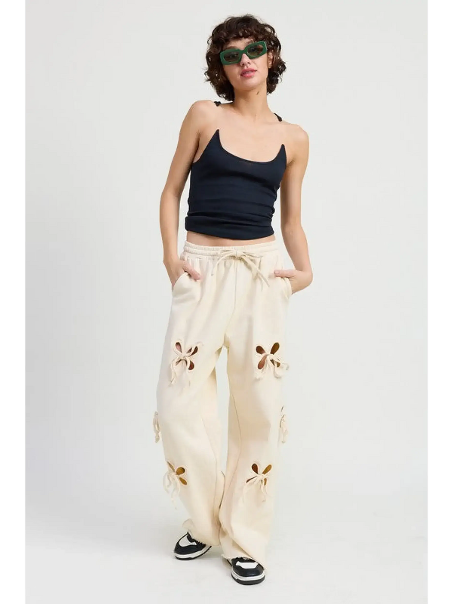 woman wearing Emory Park wide leg laser cutout cotton beach pants in cream with floral cutout details