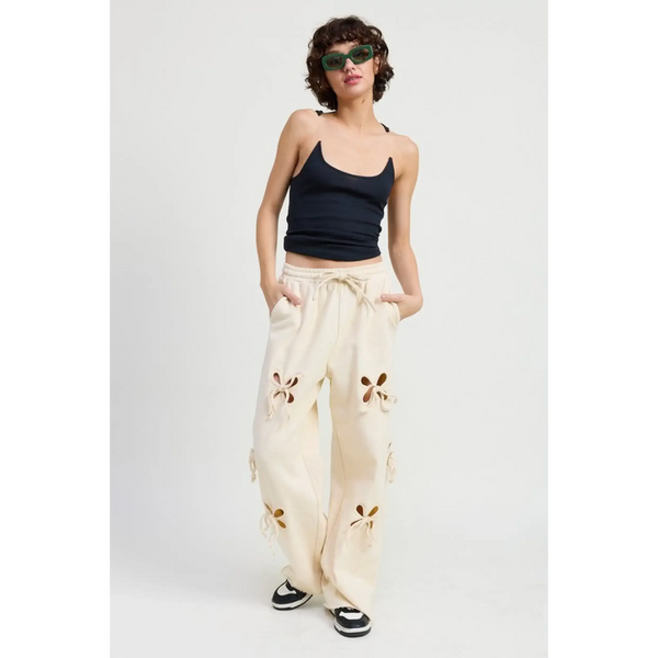 woman wearing Emory Park wide leg laser cutout cotton beach pants in cream with floral cutout details