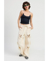 woman wearing Emory Park wide leg laser cutout cotton beach pants in cream with floral cutout details
