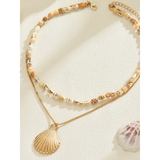 Trendsi Layered Shell Necklace featuring a delicate shell chain and gold pendant on a light background