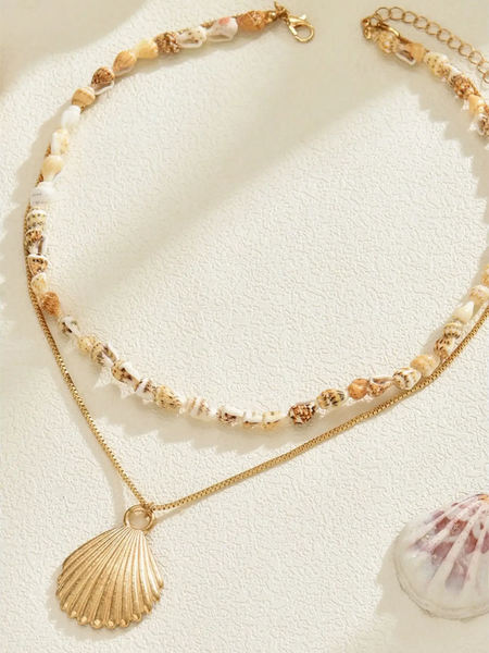 Trendsi Layered Shell Necklace featuring a delicate shell chain and gold pendant on a light background