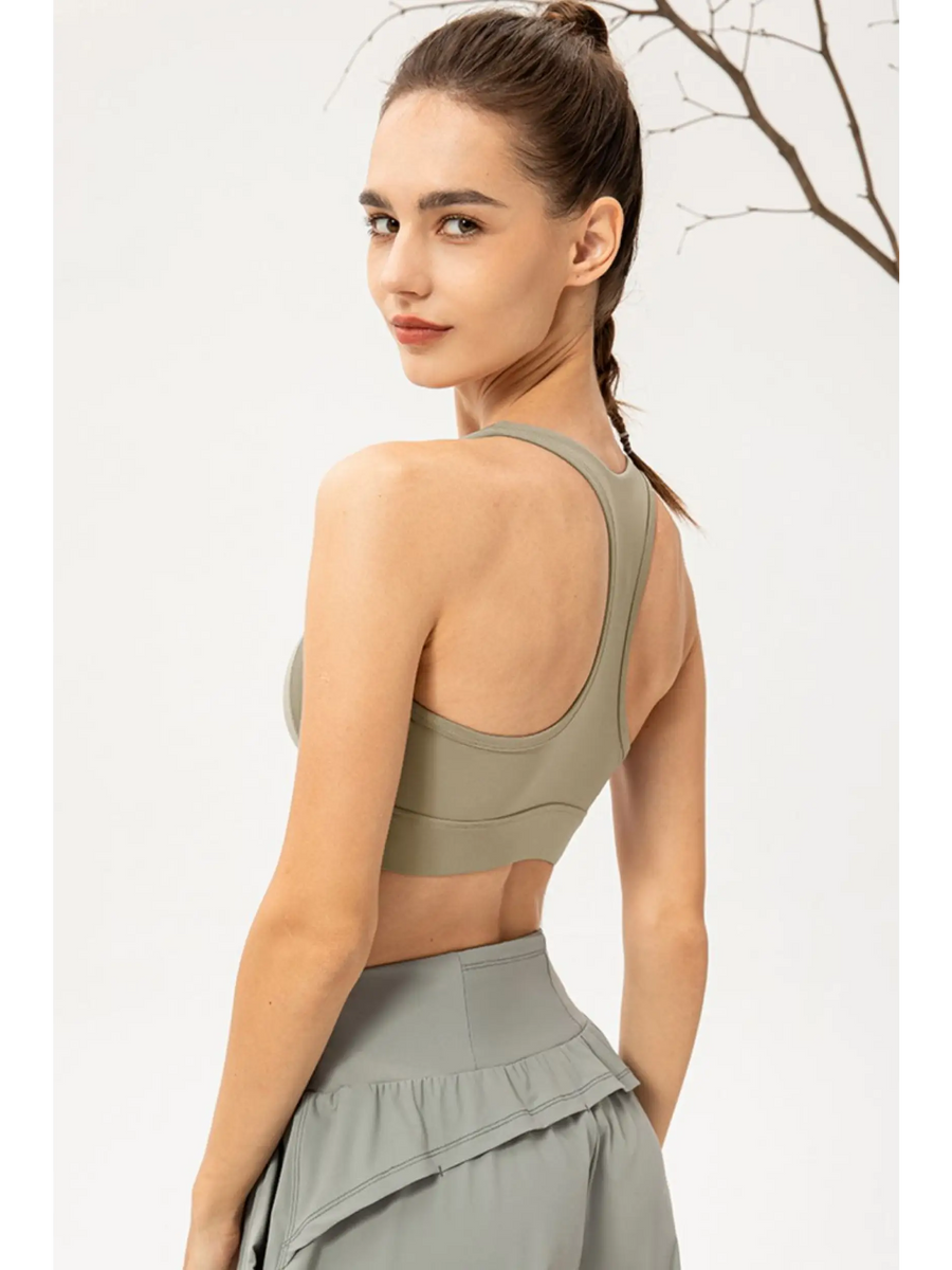 Rear view of woman wearing Babe Beachwear light blue zip front sports bra with racerback design