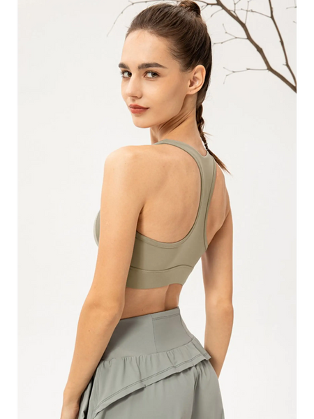 Rear view of woman wearing Babe Beachwear light blue zip front sports bra with racerback design