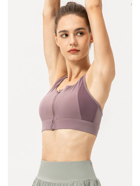 Babe Beachwaer light blue zip front sports bra worn by woman raising arms