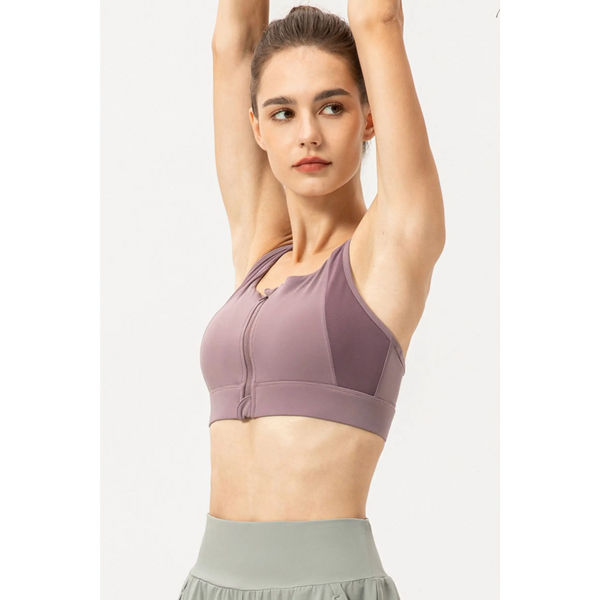 Babe Beachwaer light blue zip front sports bra worn by woman raising arms