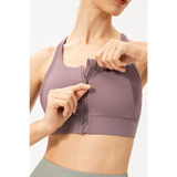 Babe Beachwear light blue zip front sports bra being zipped up on a woman in a close-up