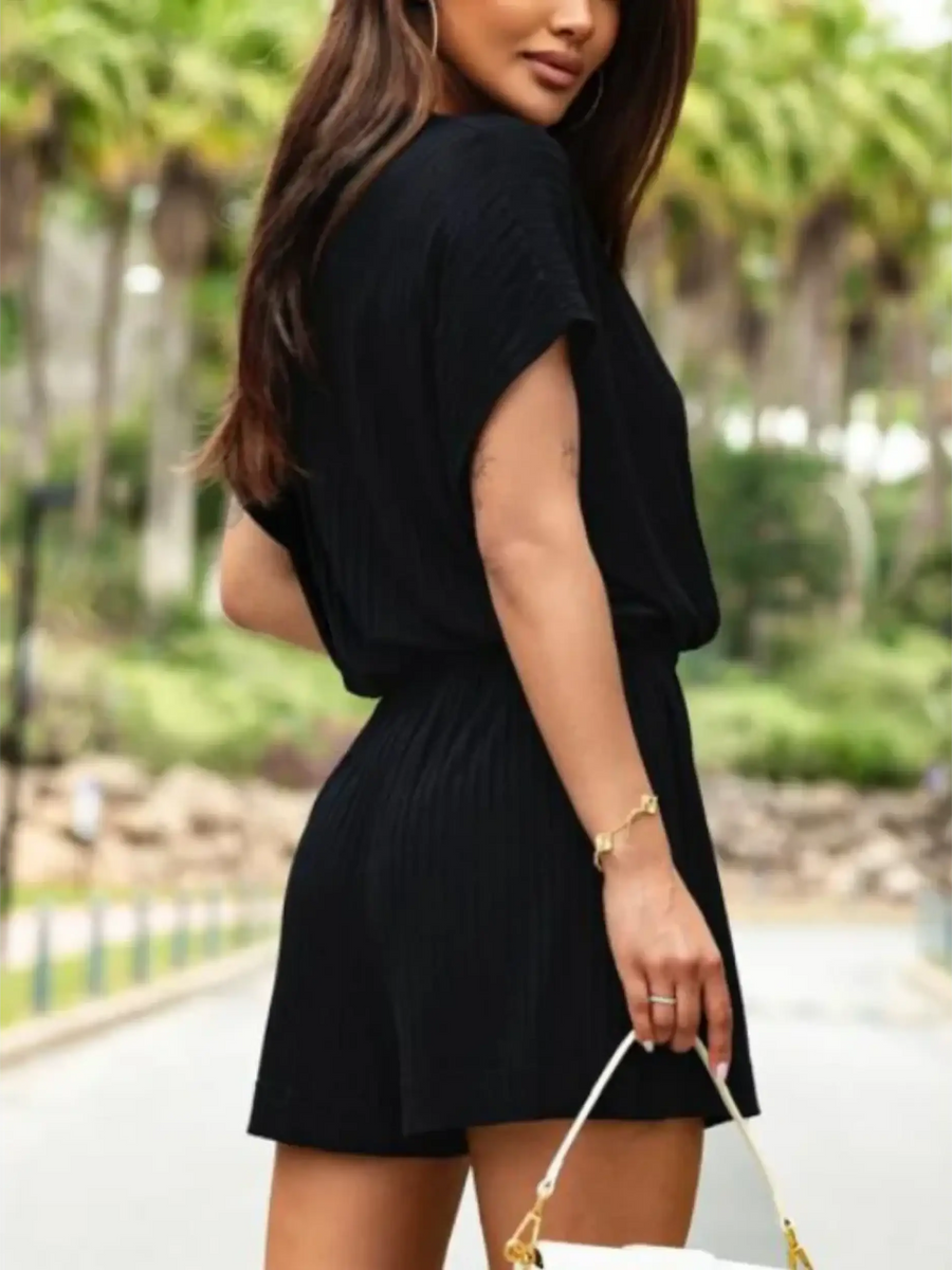 Trendsi lightweight dolman sleeve classy romper in black worn outdoors with a white handbag