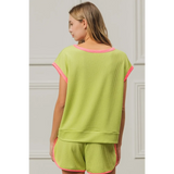 Trendsi lime and pink sleeveless shirt with pink trim on sleeves and neckline worn by woman