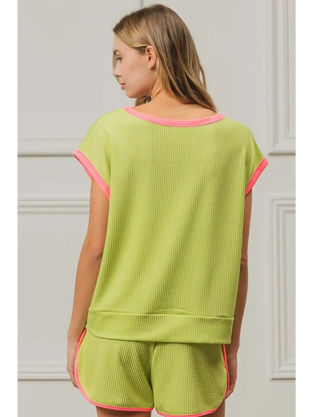 Trendsi lime and pink sleeveless shirt with pink trim on sleeves and neckline worn by woman