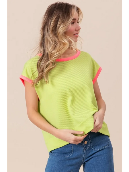 Trendsi lime and pink sleeveless shirt worn by woman with loose waves and blue jeans