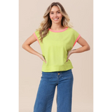 Trendsi lime and pink sleeveless shirt with ribbed texture worn by smiling woman paired with blue jeans