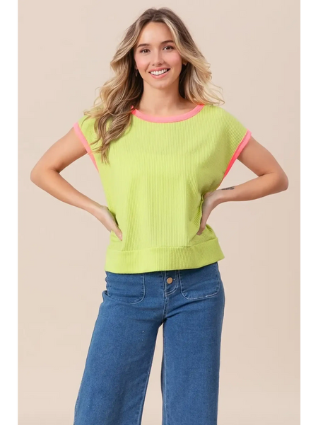 Trendsi lime and pink sleeveless shirt with ribbed texture worn by smiling woman paired with blue jeans