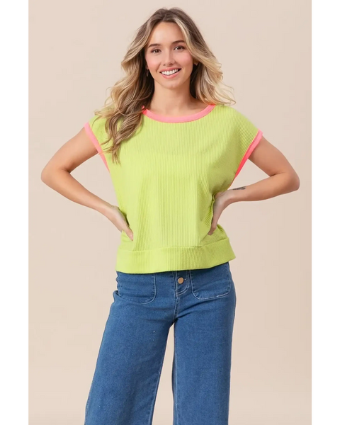Trendsi lime and pink sleeveless shirt with ribbed texture worn by smiling woman paired with blue jeans