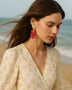 Trendsi Lobster Drop Earrings Resort in red worn by woman at the beach with beige floral dress