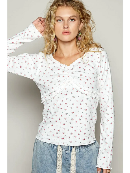 white long sleeve beachwear top with small floral print on female model