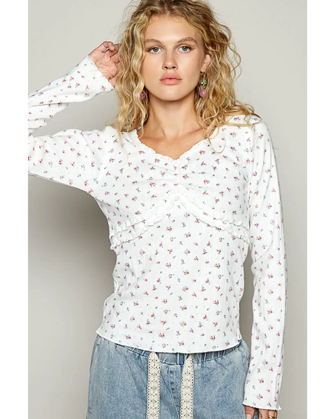 white long sleeve beachwear top with small floral print on female model