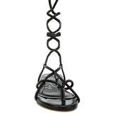 Rag Company black lace-up sandals featuring intricate straps and a flat sole design