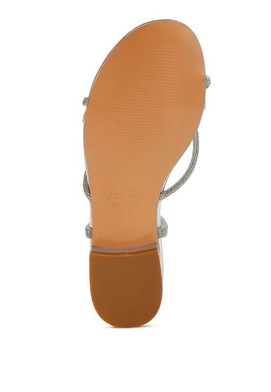 Bottom view of Rag Company gold strappy sandals with a smooth tan sole and low heel