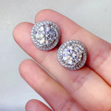 Trendsi 6 carat Stud Diamond Sterling Silver earrings held between fingers with sparkling round stones