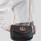 Luxury GC Logo Chain Flap Bag in black leather with gold hardware worn crossbody