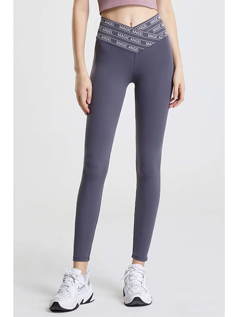 Babe Beachwaer high waisted workout leggings for women in gray with crisscross waistband and white sneakers
