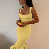 Trendsi yellow sleeveless maxi mermaid dress with ruffle hem worn by woman holding fruit