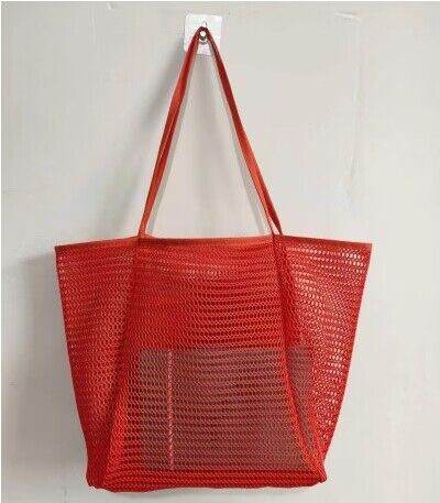 Red Mesh Beach Bag Tote Bag with long handles by Babe Beachwaer hanging on wall hook