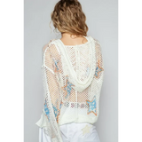 Back view of a white mesh long sleeve summer knit top with star patterns worn by a model