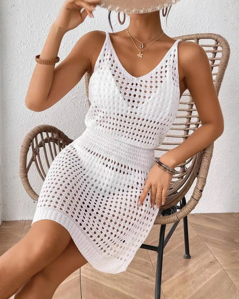 White mesh swimsuit coverup mini dress by Babe Beachwear worn by woman sitting on wicker chair