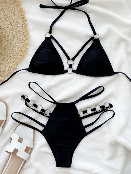 Beach Babes black bikini swimsuit with unique strap details Miami style swimwear for women laid on white fabric