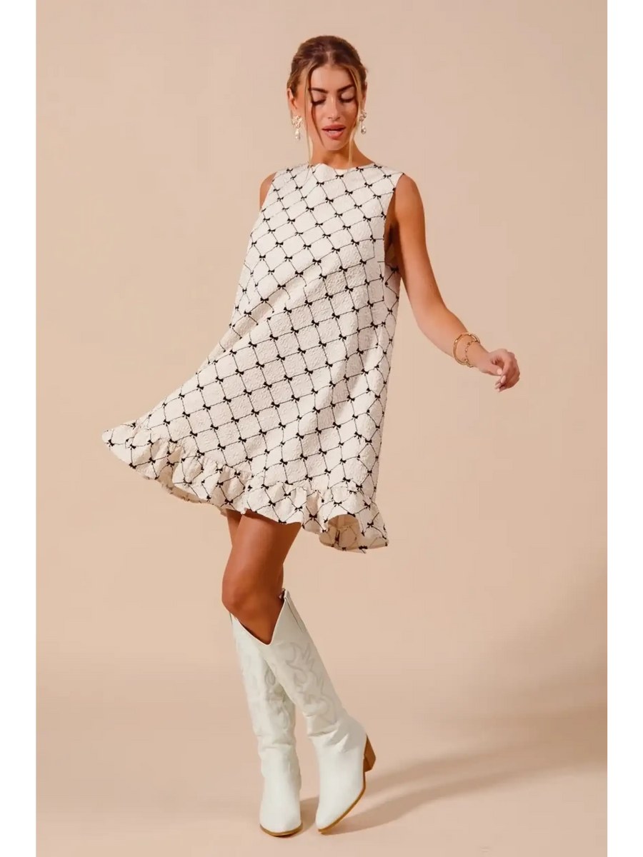 Trendsi sleeveless Mini Ruffle Dress with black pattern and ruffled hem paired with white boots
