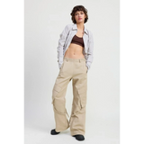 Woman wearing beige relaxed cargo pants for women with pockets, paired with striped shirt and black shoes
