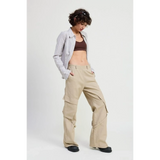 Woman wearing beige relaxed cargo pants for women with a striped shirt and dark crop top