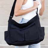 Black Nova Oversized Canvas Messanger Bag by Babe Beachwaer worn on shoulder with multiple front pockets