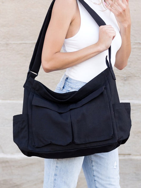 Black Nova Oversized Canvas Messanger Bag by Babe Beachwaer worn on shoulder with multiple front pockets