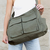 Babe Beachwear Nova Oversized Canvas Messanger Bag in olive green worn over shoulder with multiple front pockets