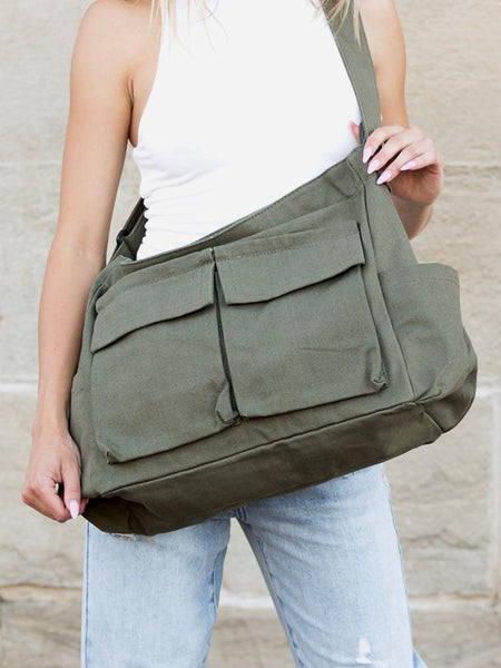 Babe Beachwear Nova Oversized Canvas Messanger Bag in olive green worn over shoulder with multiple front pockets