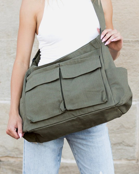 Babe Beachwear Nova Oversized Canvas Messanger Bag in olive green worn over shoulder with multiple front pockets