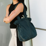Nylon Lightweight Weekender Gym Bag by Babe Beachwaer in dark green carried by a woman in sporty outfit