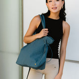 Woman carrying a Babe Beachwear Nylon Lightweight Weekender Gym Bag in teal with adjustable straps