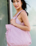 Woman carrying Babe Beachwear Nylon Lightweight Weekender Gym Bag in light pink over shoulder