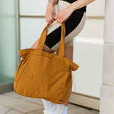 Babe Beachwear Nylon Lightweight Weekender Gym Bag in mustard yellow held by person in athletic outfit