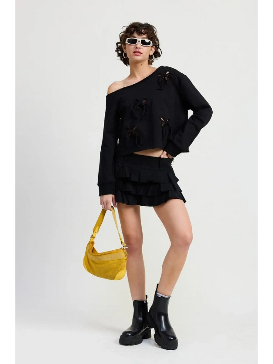 Emory Park Off Shoulder Distressed Top in black worn by model with black skirt and yellow handbag