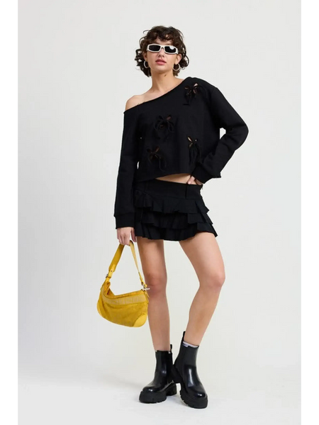 Emory Park Off Shoulder Distressed Top in black worn by model with black skirt and yellow handbag